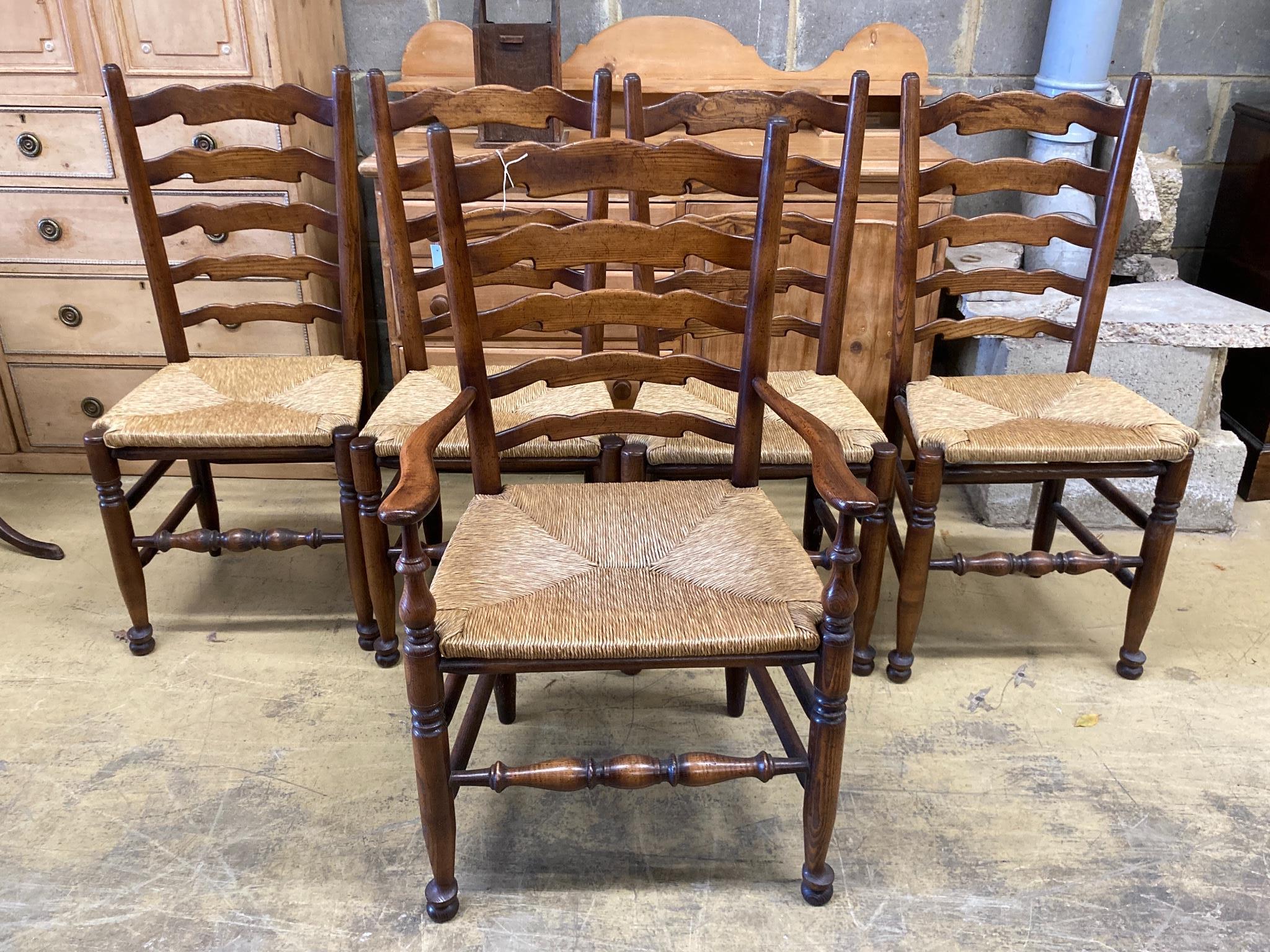 A set of five Lancashire ash and beech rush-seat ladderback chairs (one with arms)